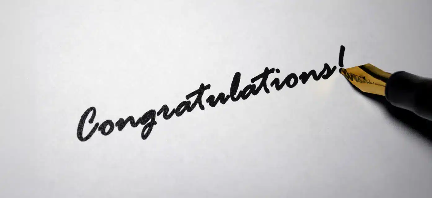Congratulations written in cursive with fancy pen.