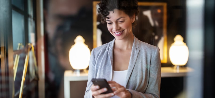 Woman in a store holds and uses mobile phone