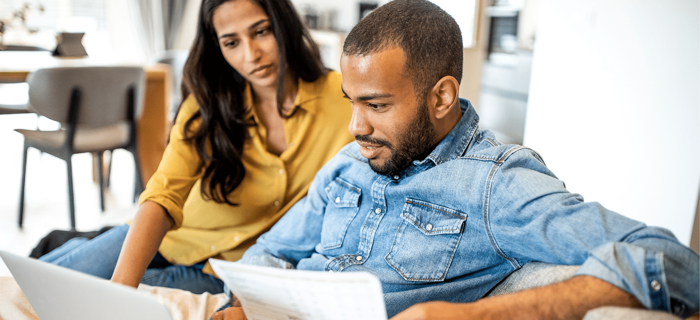 Male and female couple with a laptop reviewing docs