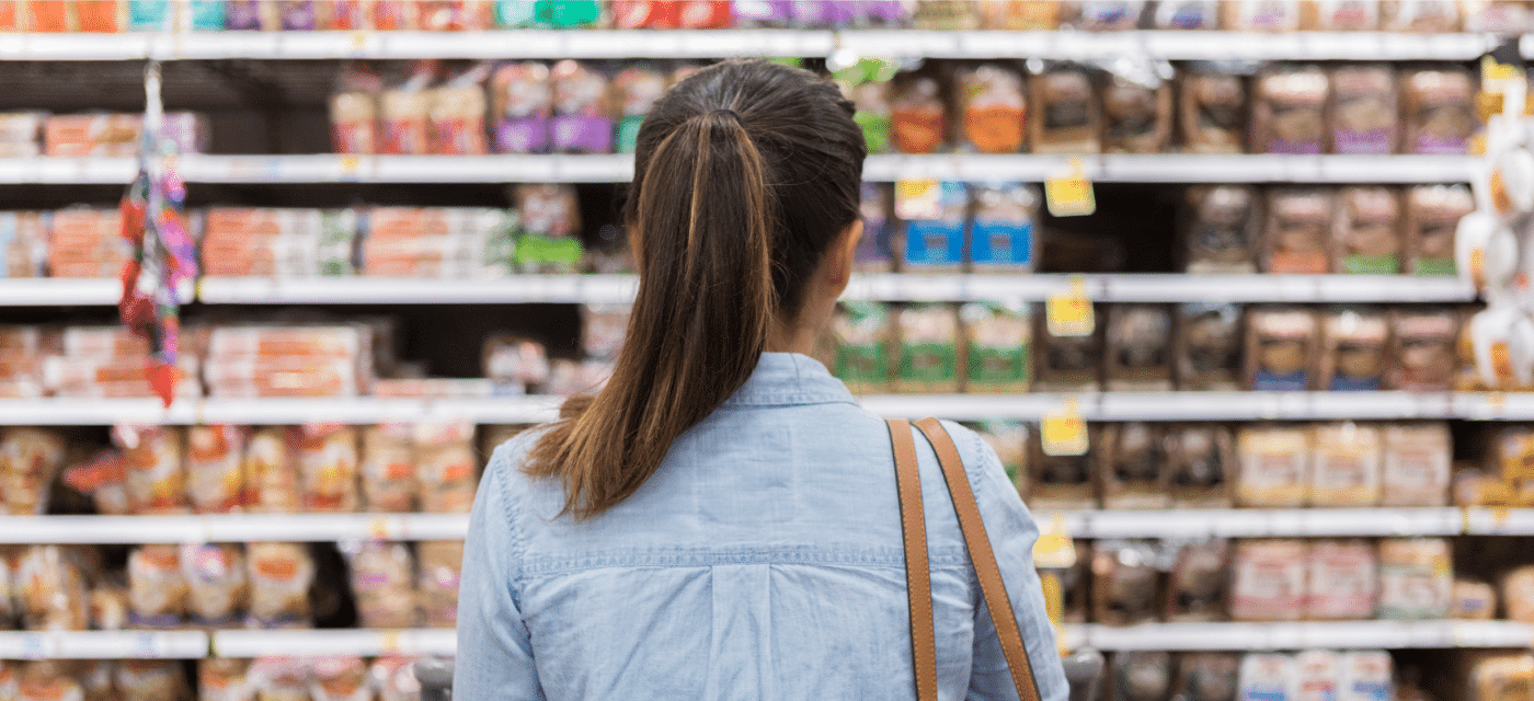 Women in grocery store looking at rows of items.