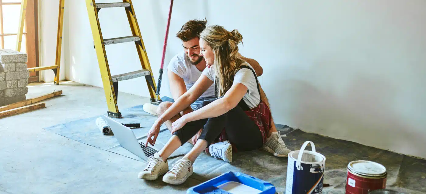 Young couple looking at a laptop about to paint