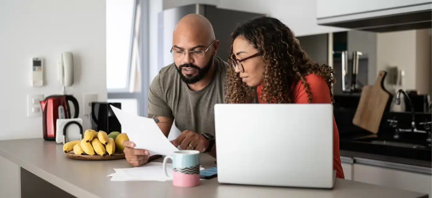 Man and woman at the kitchen island reviewing a document.