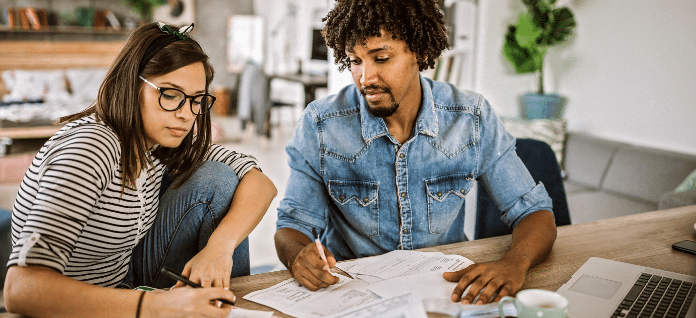 Couple sit at table and look at financial statements