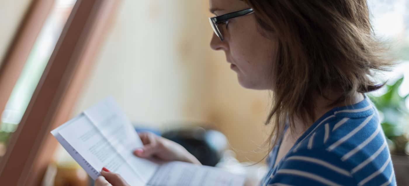 A woman reading some a paper statement.