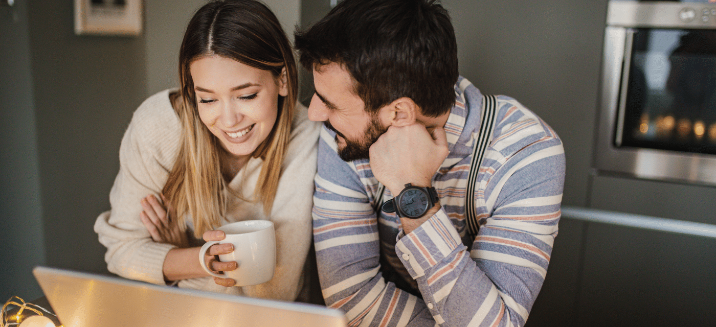 Man looking at women as she looks at a computer.