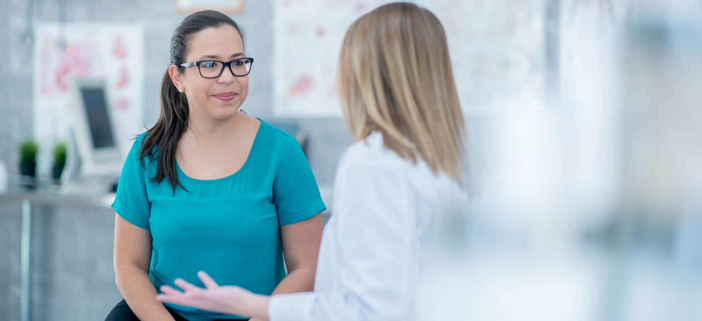 A woman talking to her doctor, who is another woman.