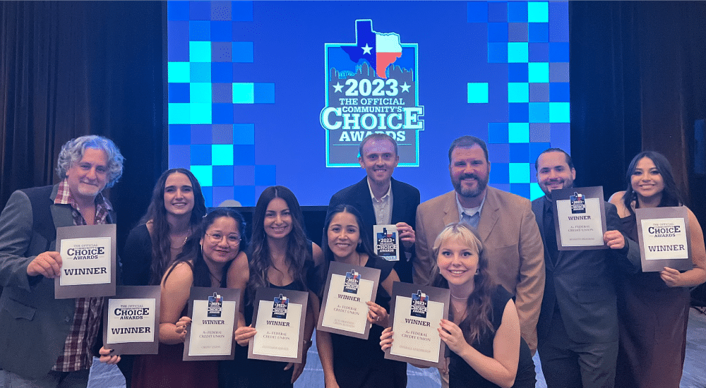 A+ team members hold certificates in front of Community Choice Awards screen