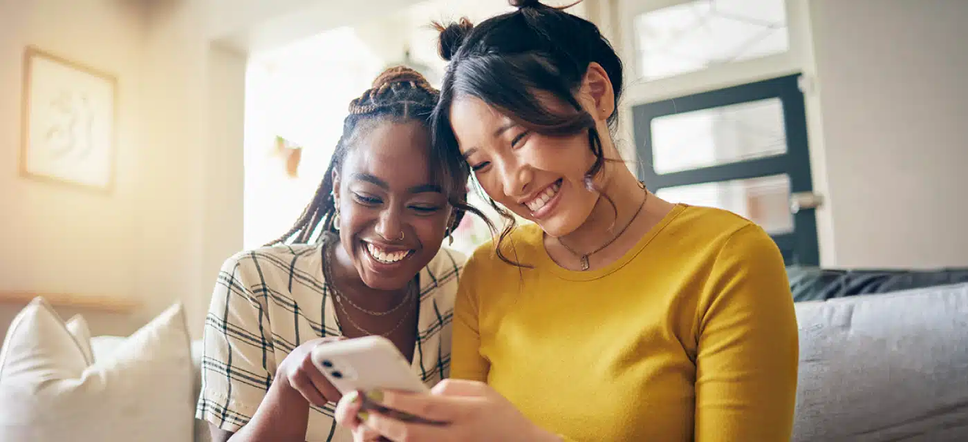 Two female friends looking at cell phone