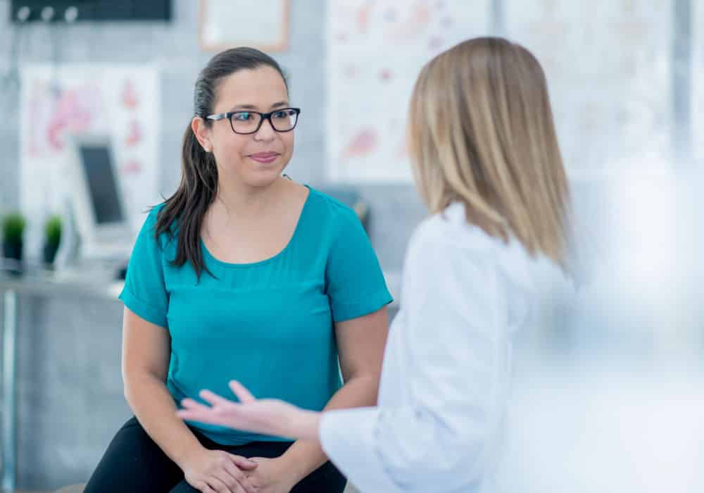 Two women sitting in an office and talking.