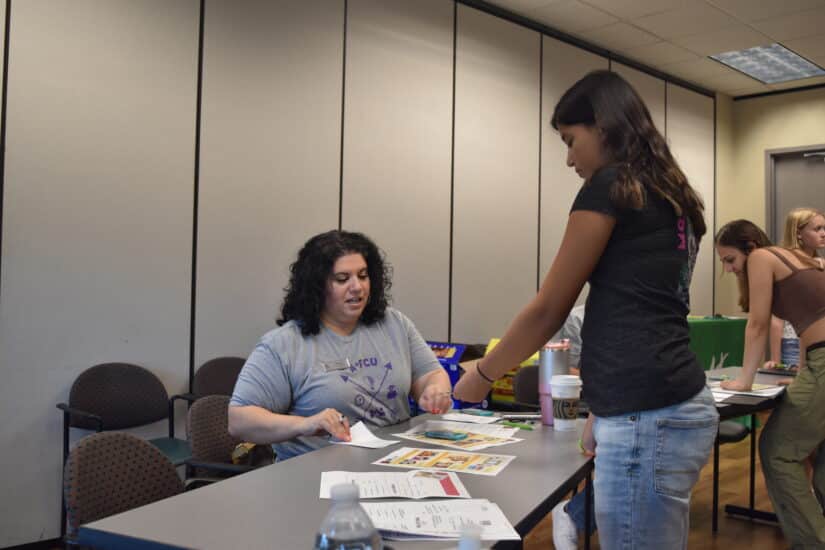 Camper making a purchase at a Mad City Money budgeting simulation table