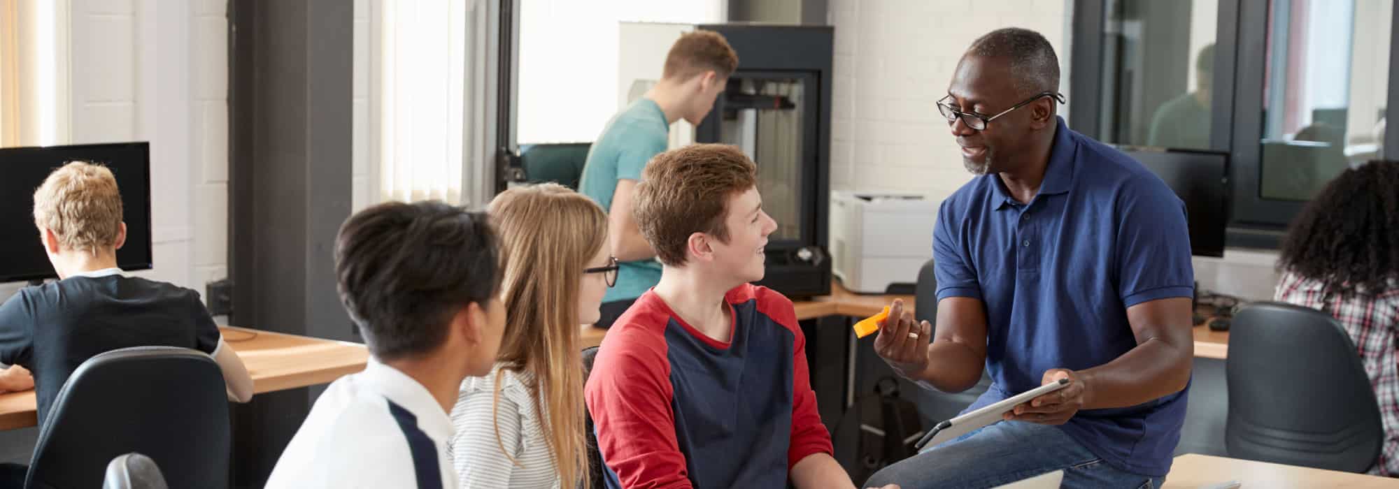 a man teaching four high school kids.