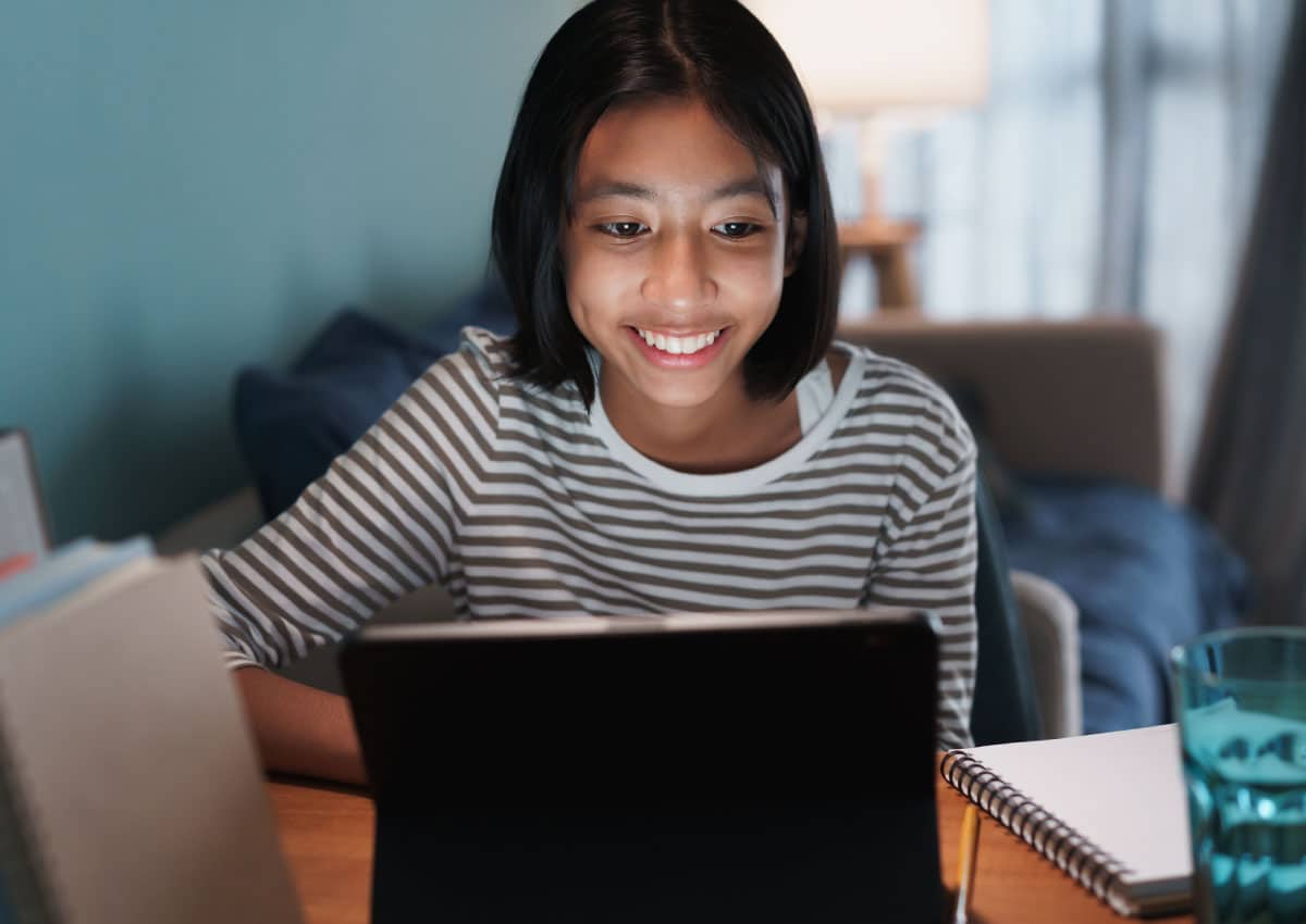 A young woman uses a laptop while sitting at a desk