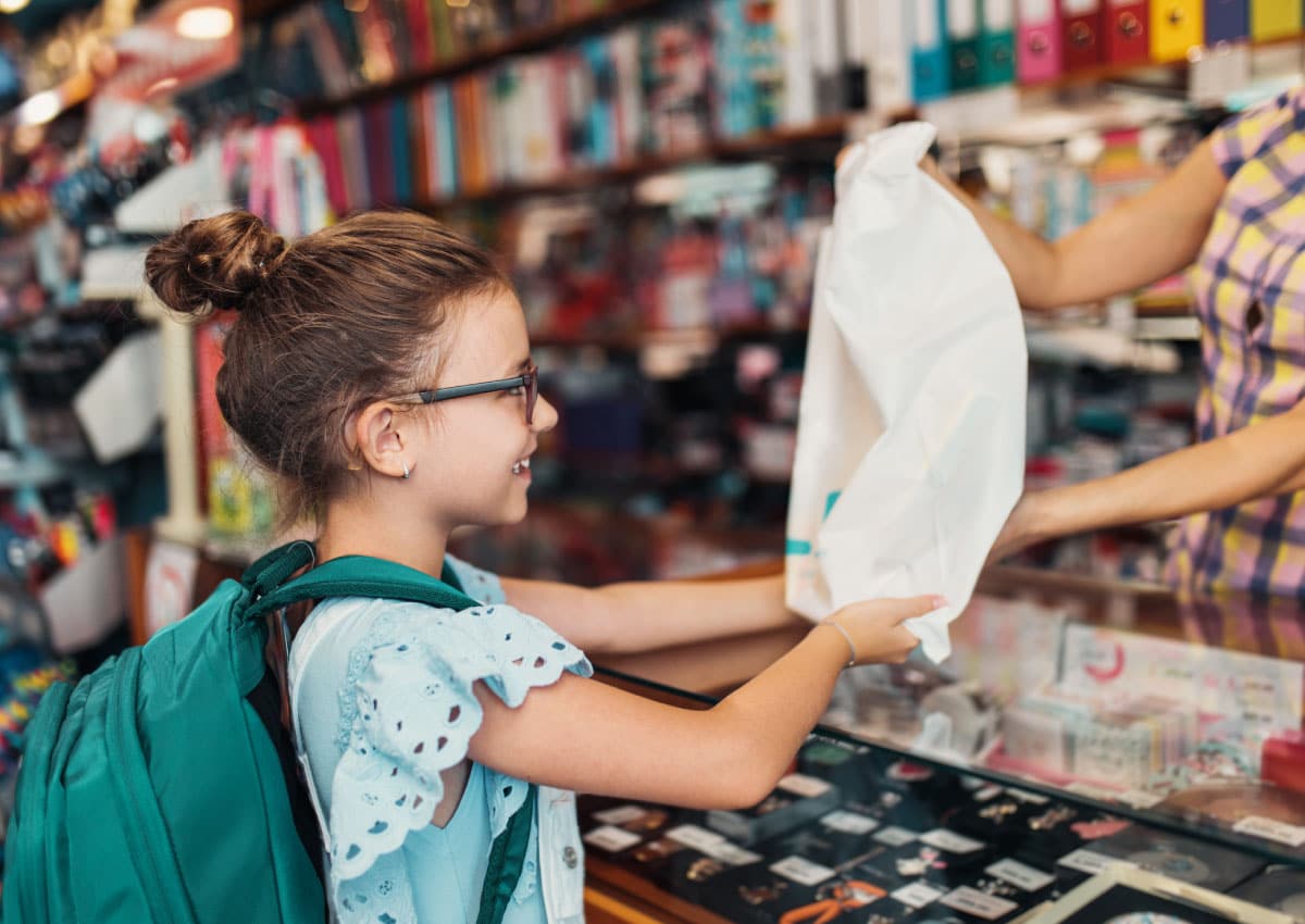 Girl receives a shopping bag from a store clerk