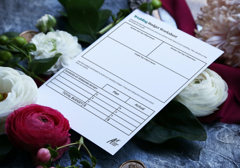 Wedding Budget Worksheet sits on flowers