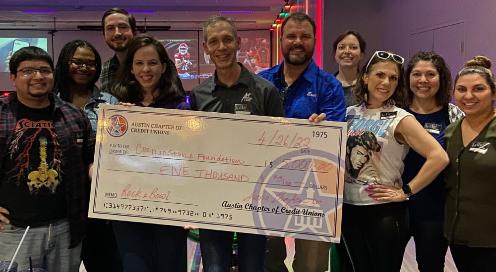 A+FCU team members hold a $5,000 donation for the Cornerstone Foundation’s Bowl For Good charity event.