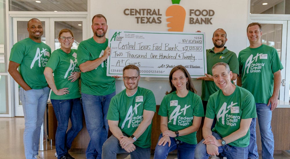 A+FCU staff members present a check to the Central Texas Food Bank for $2,120 for A+ Gives.