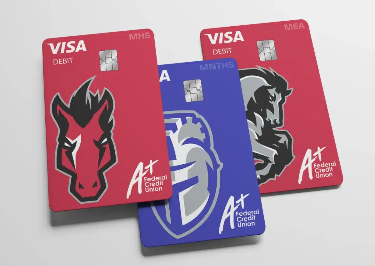 Three colorful debit/credit cards (red and blue) from a Federal Credit Union, displaying Visa Debit branding and logos like a stylized horse.