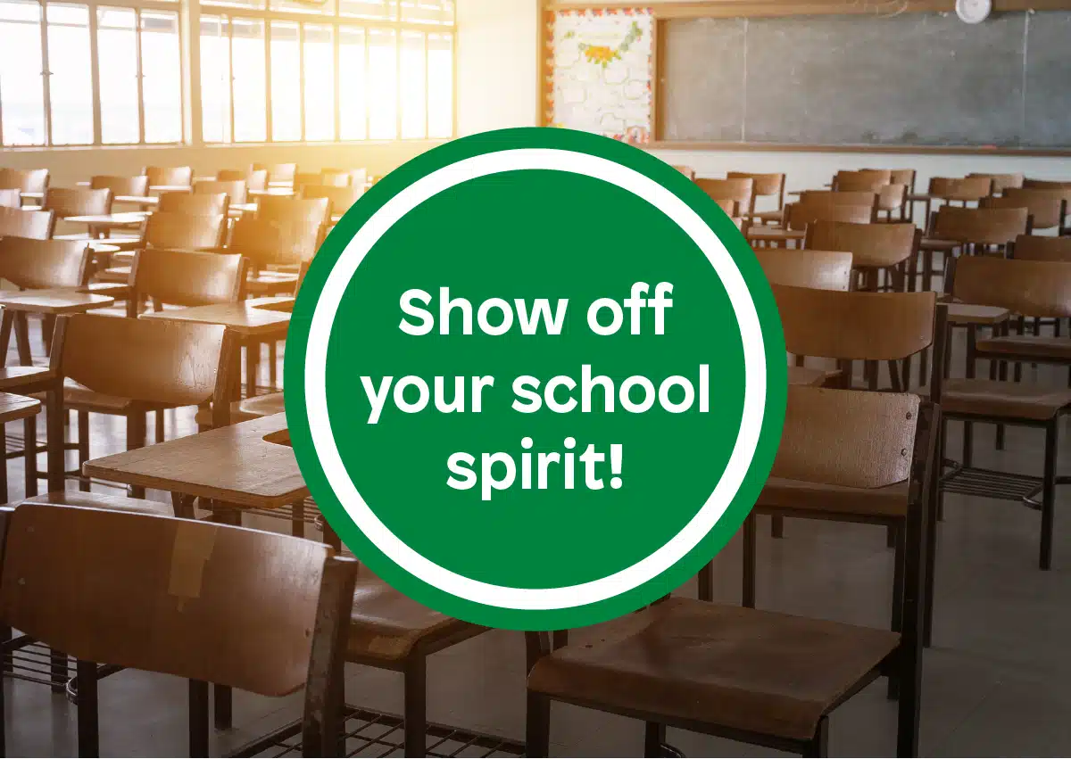 Green circular badge in a sunlit classroom displays the message 'Show off your school spirit!'