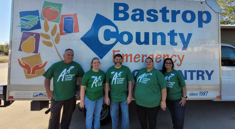 Team A+ poses in front of the Bastrop County Emergency Pantry truck.