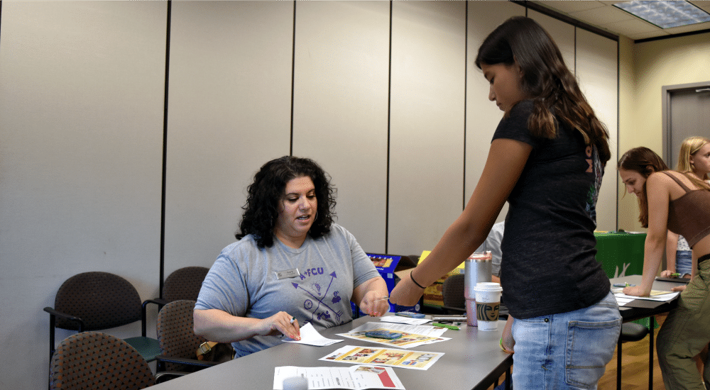 Camper making a purchase at a Mad City Money budgeting simulation table
