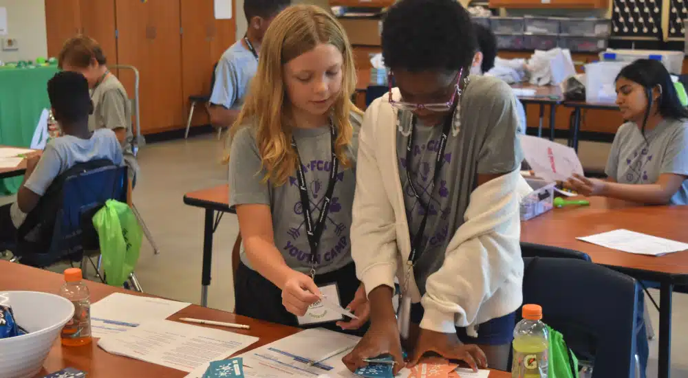 Campers work together to budget camp cash during a budget simulation.