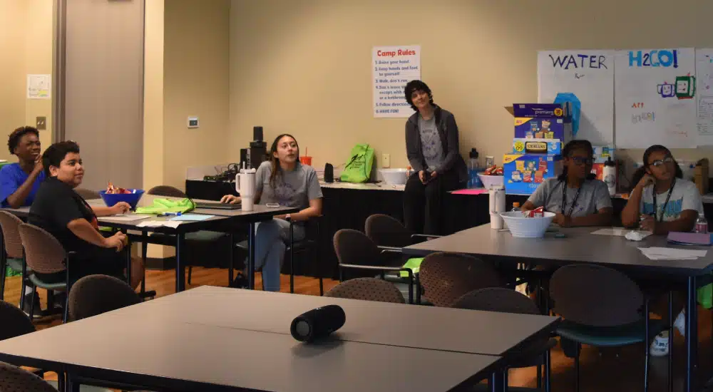 Campers watch a video about money and personal finance.